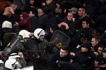 AEK Athens fans jumped onto the pitch and launched flares at the Ajax fans in the Champions League game in Greece on Tuesday night, causing police to intervene.