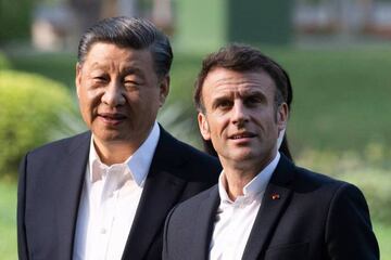 Chinese President Xi Jinping (L) and French President Emmanuel Macron (R) visit the garden of the residence of the Governor of Guangdong, on April 7, 2023, where Chinese President XI Jinping's father, XI Zhongxun lived. (Photo by Jacques WITT / POOL / AFP) (Photo by JACQUES WITT/POOL/AFP via Getty Images)