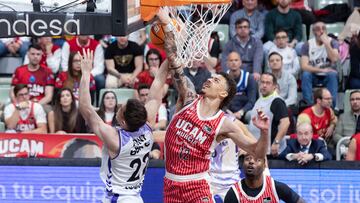 MUR01.MURCIA, 28/03/2026.- El base estadounidense de UCAM Murcia, Jonah Radebaugh (d), hace un mate al escolta de Surne Bilbao, Aleix Font (i), durante el partido de la vigésima cuarta jornada la liga Endesa que están disputando este sábado en el Palacio de los Deportes de Murcia. EFE/Marcial Guillén.