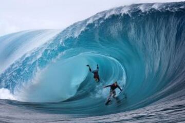 Los estadounidenses Garrett McNamara y Mark Healey compiten durante una sesión de surf, en la isla de Tahití