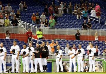 Minuto de silencio de los jugadores de Miami Marlins y los seguidores antes del comienzo del partido con los Washington Nationals en la liga de beisbol americana.