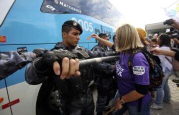 La policía intenta proteger el autobús en el que viajan los jugadores de la selección brasileña de fútbol durante una protesta de maestros de Río de Janeiro.
