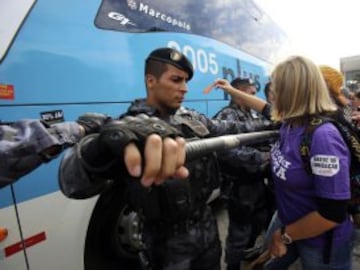 La policía intenta proteger el autobús en el que viajan los jugadores de la selección brasileña de fútbol durante una protesta de maestros de Río de Janeiro.