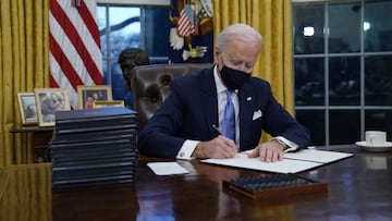 El presidente Joe Biden firma sus primeras órdenes ejecutivas en la Oficina Oval de la Casa Blanca el miércoles 20 de enero de 2021 en Washington.