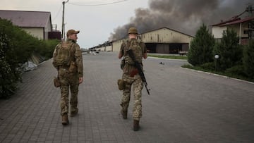 Ukrainian servicemen walk as seeds burn in a grain silos after it was shelled repeatedly, amid Russia&#039;s invasion of Ukraine, in Donetsk region, Ukraine May 31, 2022.  REUTERS/Serhii Nuzhnenko