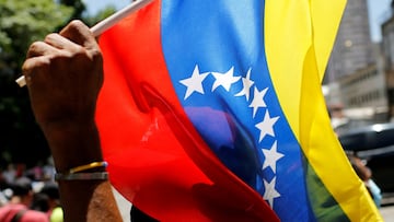 FILE PHOTO: A supporter of Venezuela's President Nicolas Maduro holds a Venezuelan flag during the May Day celebrations in Caracas, Venezuela May 1, 2022. REUTERS/Leonardo Fernandez Viloria/File Photo