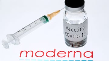 (FILES) This file photo taken on November 18, 2020 shows a syringe and a bottle reading "Vaccine Covid-19" next to the Moderna biotech company logo. - The US Food and Drug Administration on December 15, 2020, issued a positively-worded briefing document about the Moderna Covid-19 vaccine ahead of a meeting by experts on whether to grant it emergency approval. The FDA was upbeat on the vaccine, saying there were "no specific safety concerns identified that would preclude issuance of an EUA (emergency use authorization" and confirmed an overall efficacy of 94.1 percent. (Photo by JOEL SAGET / AFP)