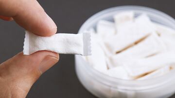 caucasian person holds snus tobacco pouch over black background. copy space. alternative chewing nicotine smoking.