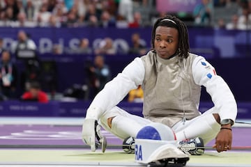 El francés Enzo Lefort sentado reflexionando tras perder en la semifinal de florete masculino ante el chino Ziwei Mo.