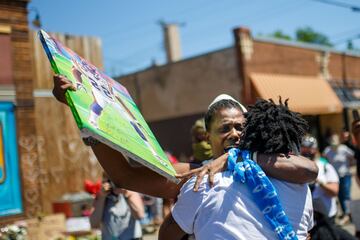 Friends of George Floyd hug and cry by a makeshift memorial in honor of George Floyd, who died while in custody of the Minneapolis police, following a day of demonstration in a call for justice on May 30, 2020 in Minneapolis, Minnesota. - Demonstrations are being held across the US after George Floyd died in police custody on May 25. (Photo by Kerem Yucel / AFP)