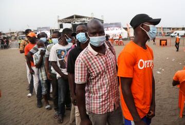 Ivory Coast fans wearing protective masks stand in line as they arrive to watch the Africa Cup of Nations soccer match between Equatorial Guinea and Ivory Coast on a big screen in Abidjan, Ivory Coast January 12, 2022. Picture taken January 12, 2022. REUT