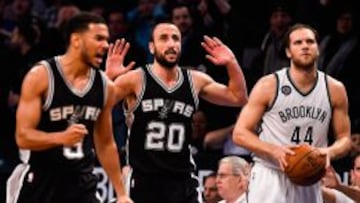 Cory Joseph y el croata Bojan Bogdanovic (Nets), flanquean a Manu Gin&oacute;vili.