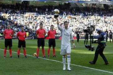 Cristiano ofrece a la grada del Santiago Bernabéu su cuarto galardón como mejor futbolista del mundo.