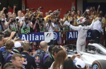El piloto inglés Lewis Hamilton celebra la victoria con su equipo.