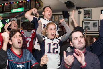 Los aficionados de los Patriots se reunieron en bares para ver el partido mientras comían alitas y bebían cervezas. En la imagen seguidores celebrando el touchdown de Sony Michel.