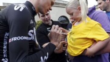 Christopher Froome firma un autógrafo en la camiseta de una joven aficionada, ayer en Leeds, punto de partida del Tour de Francia.