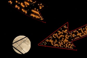 La luna se eleva tras un cartel antiguo en la cima de un edificio de apartamentos en el centro de la ciudad, el mi¨¦rcoles 16 de octubre de 2024, en Kansas City.