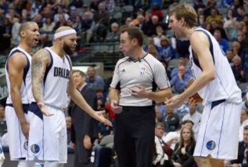 Devin Harris, Deron Williams y Dirk Nowitzki de los Dallas Mavericks hablan con el árbitro Josh Tiven.