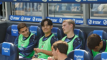 El futbolista japonés de la Real Sociedad, Take Kubo, sonríe en el banquillo durante el partido de LaLiga EA Sports disputado contra el Levante en Anoeta. EFE/Javier Etxezarreta