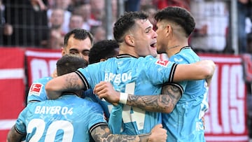 Bayer Leverkusen's Spanish defender #20 Alejandro Grimaldo (L), Bayer Leverkusen's Swiss midfielder #34 Granit Xhaka and teammates celebrate the 2-0 goal during the German first division Bundesliga football match FC Cologne v Bayer 04 Leverkusen in Cologne, western Germany on March 3, 2024. (Photo by INA FASSBENDER / AFP) / DFL REGULATIONS PROHIBIT ANY USE OF PHOTOGRAPHS AS IMAGE SEQUENCES AND/OR QUASI-VIDEO