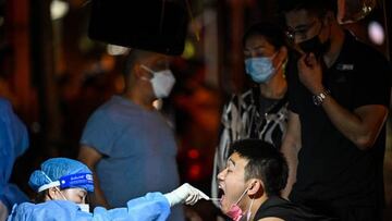 A health worker takes a swab sample from a man to test for the Covid-19 coronavirus in the Huangpu district of Shanghai, on September 20, 2022. (Photo by Hector RETAMAL / AFP) (Photo by HECTOR RETAMAL/AFP via Getty Images)