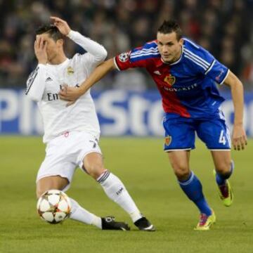 El delantero portugués del Real Madrid Cristiano Ronaldo pelea por el balón con Philipp Degen, del Basilea.