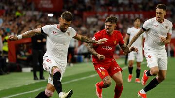 SEVILLA, 22/04/2024.- El centrocampista serbio del Sevilla Nemanja Gudelj (i) disputa un balón con el defensa hispano-argentino del Mallorca Pablo Maffeo (c) durante el partido de la jornada 32 de LaLiga celebrado este lunes en el estadio Sánchez Pizjuán de Sevilla. EFE/ Julio Muñoz