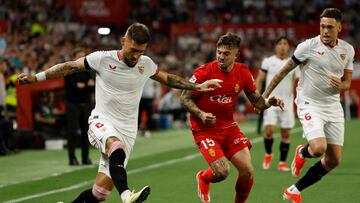 SEVILLA, 22/04/2024.- El centrocampista serbio del Sevilla Nemanja Gudelj (i) disputa un balón con el defensa hispano-argentino del Mallorca Pablo Maffeo (c) durante el partido de la jornada 32 de LaLiga celebrado este lunes en el estadio Sánchez Pizjuán de Sevilla. EFE/ Julio Muñoz
