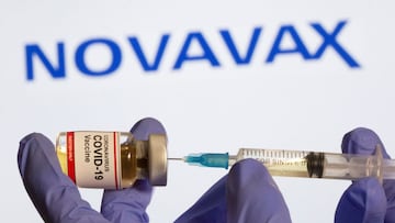 FILE PHOTO: A woman holds a small bottle labeled with a "Coronavirus COVID-19 Vaccine" sticker and a medical syringe in front of displayed Novavax logo in this illustration taken, October 30, 2020. REUTERS/Dado Ruvic/File Photo