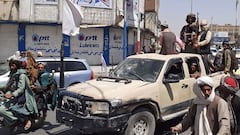 Taliban fighters drive an Afghan National Army (ANA) vehicle through a street in Kandahar on August 13, 2021.