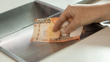 Chile money, Woman standing at the cash desk with cash, Concept, Cash deposit and withdrawal, Financial operations, banking, loans, money exchange, capital investment, financial institution