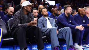 Jimmy Butler y Stephen Curry, vestido de calle en el banquillo de los Warriors durante un partido de esta temporada.