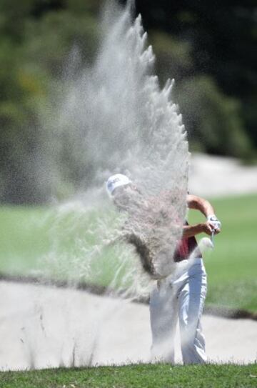 El golfista australiano, Aaron Baddeley, golpea la bola desde la arena durante el Abierto de Australia de golf. 