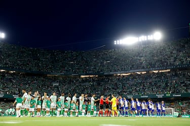 Los jugadores del Betis y Atético de Madrid se saludan en el césped del estadio Benito Villamarín.