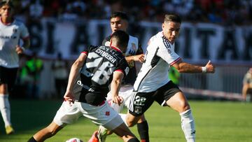 El jugador de Colo Colo, Óscar Opazo, disputa el balón con Sebastian Cabrera de Curicó Unido durante el partido de Primera División.