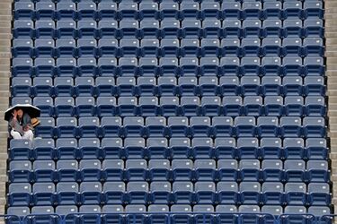 Una solitaria espectadora, en una grada totalmente desierta, se protege bajo un paraguas durante el WTA 1000 de tenis de Dubái. Se disputaba el partido de segunda ronda entre la alemana Eva Lys y la italiana Jasmine Paolini cuando la lluvia obligó a la suspensión temporal del mismo, aunque esta fiel aficionada se mantuvo en su localidad hasta la reanudación.