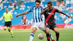 SAN SEBASTI&Aacute;N, 22/08/2021.- El centrocampista de la Real Sociedad Mart&iacute;n Zubimendi (i) pelea un bal&oacute;n con el centrocampista argentino del Rayo Vallecano &Oacute;scar Trejo durante el partido de LaLiga, este domingo en el Reale Arena. 