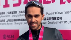 Alberto Contador muestra la medalla de ganador de una carrera en China.