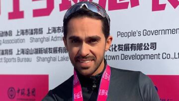 Alberto Contador muestra la medalla de ganador de una carrera en China.