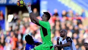 Getafe's Spanish goalkeeper Vicente Guaita (C) jumps to grab the ball next to Getafe's Togolese defender Dakonam Djene (L) and Valencia's Italian forward Simone Zaza (R) during the Spanish league football match Getafe CF vs Valencia CF at the Col. Alfonso Perez stadium in Getafe on December 3, 2017. / AFP PHOTO / JAVIER SORIANO