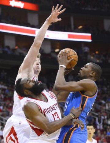 Kevin Durant (D) trata de anotar ante James Harden (C) y Omer Asik (I).