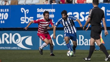 Dos jugadores pelean por un balón en el Lorca-Granada.
