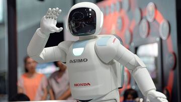 (FILES) This picture taken on July 3, 2013 shows Honda Motor's humanoid robot Asimo interacting with visitors at the National Museum of Emerging Science and Innovation in Tokyo on July 3, 2013.
Launched in 2000, the humanoid machine resembling a shrunken spaceman has become arguably Japan's most famous robot, wheeled out to impress visiting politicians over the years. / AFP PHOTO / YOSHIKAZU TSUNO