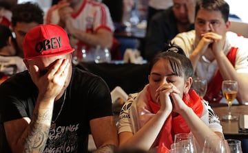 Fans of Argentina's River Plate team react after their team lost 2-1 the Copa Libertadores football final against Brazil's Flamengo at a bar in Buenos Aires, on November 23, 2019. 