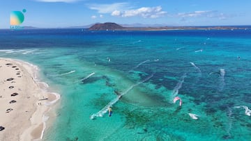 La playa de La Oliva (Fuerteventura) desde el aire, con aguas cristalinas y gente practicando kitesurf.