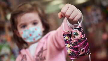 Una ni&ntilde;a muestra una mascarilla infantil mientras sale a la calle en Pamplona a finales de abril.