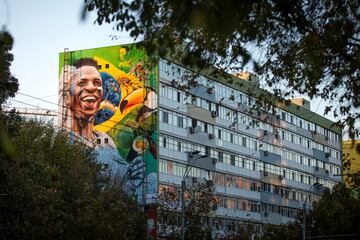 Esta imagen muestra un mural de Vinicius Jr. en un bloque de diez pisos en el centro de Bucarest. Su autor es el brasileño Fabio Gomes Trindade, famoso por sus pinturas inspiradas en la naturaleza y en la lucha racial. Es la primera obra del artista brasileño en Europa, coincidiendo con el Outline Streetart Festival de la capital rumana.   