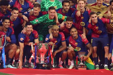 Los jugadores del Barcelona posan con los trofeos de la Copa del Rey, la Liga y la Supercopa de España