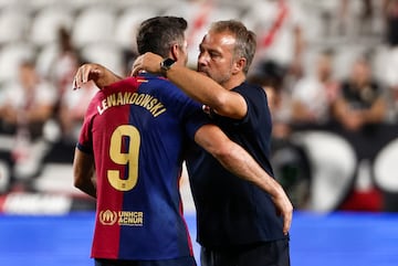 El entrenador del Barcelona, Hans-Dieter Flick (d), abraza al delantero polaco Robert Lewandowski tras el partido de Liga en Primera División que Rayo Vallecano y FC Barcelona han disputado este martes en el estadio de Vallecas, en Madrid. 