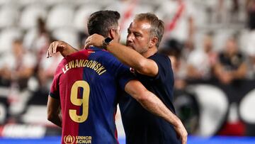 MADRID, 27/08/2024.- El entrenador del Barcelona, Hans-Dieter Flick (d), abraza al delantero polaco Robert Lewandowski tras el partido de Liga en Primera División que Rayo Vallecano y FC Barcelona han disputado este martes en el estadio de Vallecas, en Madrid. EFE/ Sergio Pérez